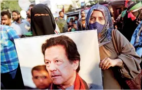  ?? ?? Pakistan Tehreek-e-Insaf (PTI) supporters hold a picture of jailed former prime minister Imran Khan during a protest outside an election commission office in Karachi on February 10, 2024. AFP