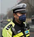  ??  ?? A policeman wears a mask to help fight the bad air pollution outside the Great Hall of the People in Beijing. — AFP photo