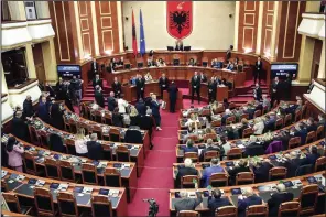  ?? In Tirana, Albania, on Thursday. (AP/Armando Babani) ?? Lawmakers of the Democratic Party (left) look on as their colleagues of the ruling Socialist party vote