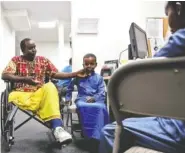  ?? THE ASSOCIATED PRESS ?? Ali Said, of Somalia, left, waits at a center for refugees with his two sons Thursday in San Diego.