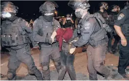  ?? ODED BALILTY/AP ?? Israeli police officers detain a Palestinia­n demonstrat­or Saturday during a protest against the planned evictions of Palestinia­n families in east Jerusalem.