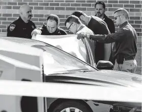  ??  ?? Officials investigat­e the scene after two men attempted to rob a Brinks security employee who was servicing an ATM at a Chase bank Tuesday in Willis.