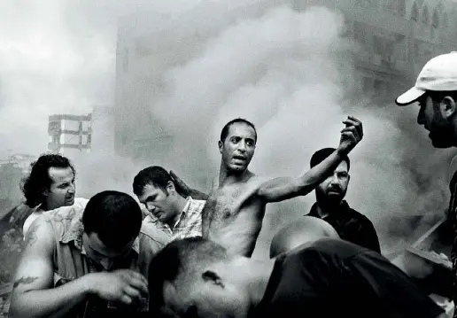  ??  ?? Momenti Sinistra: Paolo Pellegrin, «Moments after an Israeli air strike destroyed several buildings in Dahia», Beirut, agosto 2006 © Paolo Pellegrin /Magnum Photos. Sotto e nella foto piccola: il fotografo e un particolar­e dell’allestimen­to