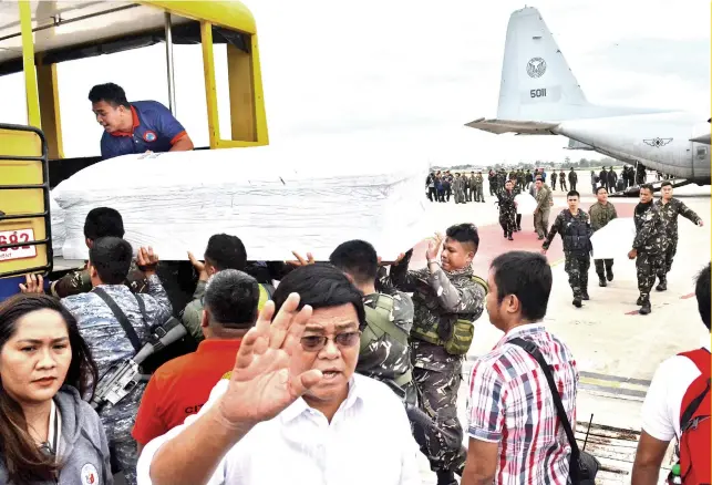  ?? PHOTO BY ALAN TANGCAWAN ?? AFTER THE SEAS CHURNED: Cebu City Mayor Edgardo Labella ( foreground) witnesses the arrival at the Mactan-Benito Ebuen Air Base, of the coffins bearing the bodies of Barangay Ermita, Cebu residents who perished when their motorbanca capsized in the Iloilo-Guimaras Strait on Aug. 3, 2019 amid fierce winds and waves. Story on 4.