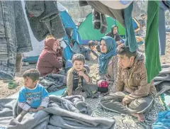  ?? NYT ?? An Afghan family gathers at the Moria refugee camp in Greece yesterday. Tens of thousands of Afghan migrants face repatriatr­ion under a new deal with Europe.