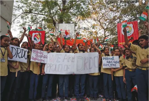  ??  ?? STUDENTS CHEER and show off celebrator­y flags and placards after India shot down one of its satellites in space with an anti-satellite missile in a test, in Ahmedabad, India, on March 27.