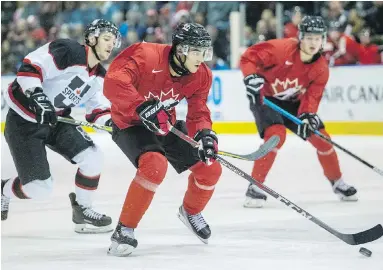  ??  ?? Team Canada centre and Detroit Red Wings draft pick Joe Veleno heads up ice in front of U Sports all-stars forward Cain Franson during exhibition action at The Q Centre on Thursday.