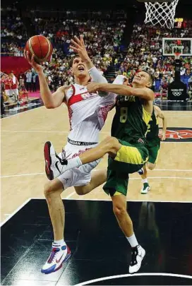  ??  ?? No easy passage: Russia’s Timofey Mozgov (left) is guarded by Lithuania’s Renaldas Seibutis during their quarter-final yesterday.