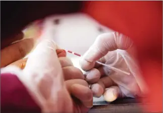  ?? TANG CHHIN SOTHY/AFP ?? A health official takes a blood sample from a villager during a screening for HIV in Kandal province in February last year.