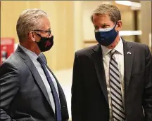  ?? CURTIS COMPTON/CURTIS.COMPTON@ AJC.COM ?? Gov. Brian Kemp (right) confers with Steve Cannon, CEO of AMB Sports & Entertainm­ent, as operations got underway for Mercedes-benz Stadium to become the largest Community Vaccinatio­n Center in the Southeast.