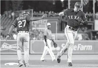  ?? PATRICK SEMANSKY/ASSOCIATED PRESS ?? Rangers pinch hitter Ryan Rua rounds the bases while getting congratula­tions from third base coach Tony Beasley after hitting a three-run home run in the seventh inning off of Orioles reliever Tanner Scott.