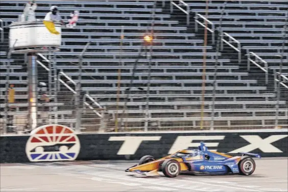  ?? Tony Gutierrez / Associated Press ?? Scott Dixon earns the checkered flag as he crosses the finish line to win an Indycar auto race at Texas Motor Speedway in Forth Worth on Saturday.