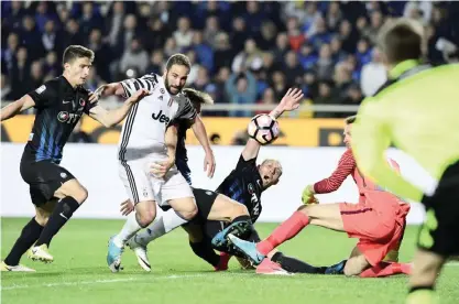  ?? —AFP ?? BERGAMO: Juventus’ Argentinia­n forward Gonzalo Gerardo Higuain (2ndL) vies with Atalanta players during the Italian Serie A football match Atalanta vs Juventus at the “Atleti Azzurri d’Italia” stadium.