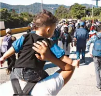  ??  ?? Decididos. Un hombre carga a su hijo mientras camina en la caravana migrante hacia Estados Unidos.