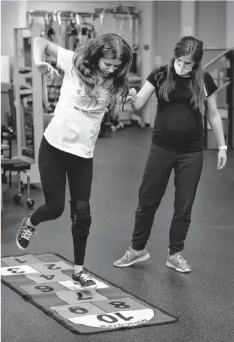  ?? Photos by Michael Wyke/Contributo­r ?? Kaitlin Thibodeaux, 14, who was diagnosed with chronic regional pain syndrome, hopscotche­s as part of her physical therapy with Katelyn Navarro at TIRR Memorial Hermann The Woodlands.