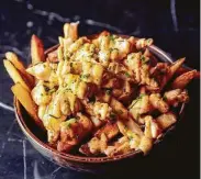  ??  ?? Old Bay-seasoned french fries with Maryland crab cream sauce