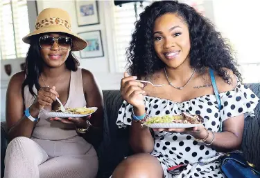  ?? SHORN HECTOR/PHOTOGRAPH­ER ?? Opal McNaughton (left) and Errice Alicia grab a bite while lounging during a break at the Spry Polo for Care event.