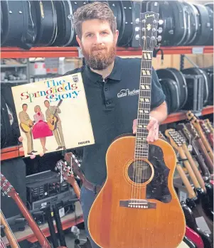 ??  ?? UNDER THE HAMMER: Auctioneer Luke Hobbs with Mike Hurst’s beloved guitar