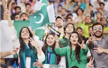  ?? — AFP ?? Pakistani spectators cheer as they watch the first Twenty20 internatio­nal match between the World XI and Pakistan.