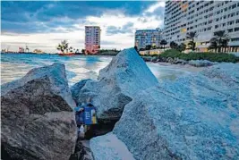  ?? JENNIFER LETT/SUN SENTINEL ?? An empty Bud Light box rests on the jetty rocks behind a condo in Fort Lauderdale on Jan. 30.