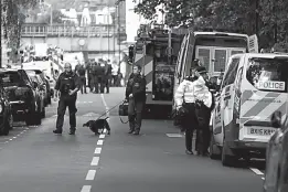  ?? Associated Press ?? Police officers walk with a dog within a cordon after a terrorist attack on Friday at Parsons Green subway station in London.