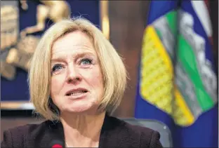  ?? CP PHOTO ?? Alberta Premier Rachel Notley speaks to cabinet members about an 8.7 per cent oil production cut to help deal with low prices, in Edmonton on Monday.