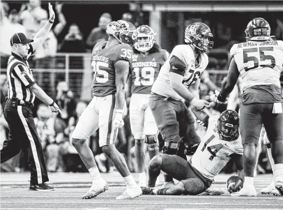  ?? Brandon Wade / Associated Press ?? Despite being down to its third-string QB in Jacob Zeno (14), Baylor made Oklahoma and linebacker Nik Bonitto (35) work to earn Saturday’s victory in overtime.