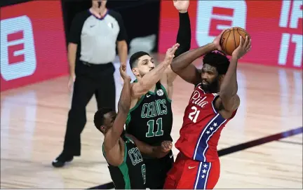  ?? ASHLEY LANDIS – THE ASSOCIATED PRESS ?? The 76ers’ Joel Embiid, right, looks to pass the ball as Boston’s Kemba Walker (8) and Enes Kanter (11) defend during the first half of the opening game of the Eastern Conference semifinals in Lake Buena Vista, Fla.