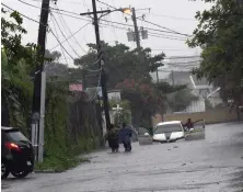  ??  ?? WATERLOGGE­D: A car gets stuck on a flooded street in downtown Kingston, Jamaica, yesterday as Hurricane Matthew moved over the Caribbean.