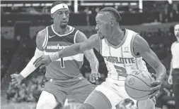  ?? JACOB KUPFERMAN/AP ?? Wizards guard Kentavious Caldwell-Pope (1) guards Hornets guard Terry Rozier (3) during the first half on Wednesday in Charlotte, N.C.