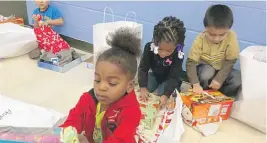  ?? SUN- TIMES LIBRARY ?? The kids of the North Chicago Head Start program open gifts on Dec. 16, 2016. |