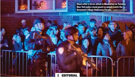  ??  ?? Hours after a terror attack in Manhattan on Tuesday, New York police stand guard as people watch the Greenwich Village Halloween Parade.
| ANDRES KUDACKI/ AP