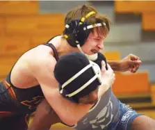  ??  ?? Above: Dade County’s Garrett Dunn wrestles Elbert County’s Tyshawn Hughes in a 120-pound bout. Left: Dade County coach Jeff Poston talks to the referee about a call during a match Saturday.