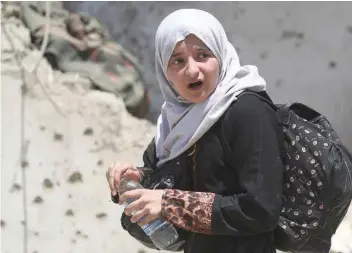  ?? — AFP ?? An Iraqi girl flees from the Old City of Mosul during the ongoing offensive by Iraqi forces to retake the last district still held by the IS group.