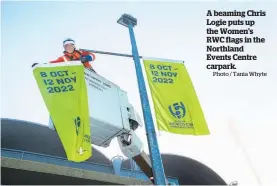  ?? Photo / Tania Whyte ?? A beaming Chris Logie puts up the Women's RWC flags in the Northland Events Centre carpark.