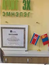  ?? LE DEVOIR ?? Dans le hall d’une clinique à Oulan-Bator, un certificat d’autorisati­on délivré par le gouverneme­nt mongol au côté des drapeaux nord-coréen et mongol