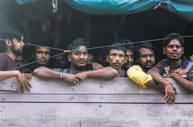  ?? Binsar Bakkara / Associated Press ?? Bangladesh­i men head to an immigratio­n center in Medan, Indonesia, after some were found locked in a house, waiting to be taken to palm oil plantation­s.