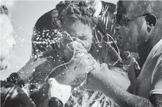  ?? SCOTT MCINTYRE/THE NEW YORK TIMES PHOTOS ?? Alexandra Edward, 10, closes her eyes and holds her nose as she is baptized Nov. 7 in the Atlantic Ocean near Palm Beach.