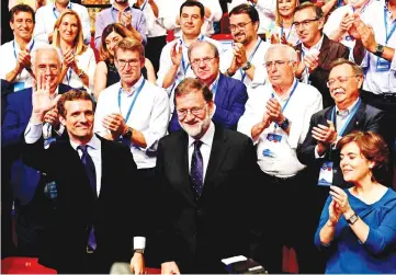  ??  ?? Casado (left) celebrates after winning a Popular Party election to succeed Rajoy (centre) against Saenz de Santamaria at the end of a meeting to elect the conservati­ve party’s next leader in Madrid. — AFP photo