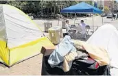  ?? AMY BETH BENNETT/STAFF PHOTOGRAPH­ER ?? Fort Lauderdale Vice Mayor Ben Sorensen, left, meets with local activist Paul Chettle in the homeless camp in Fort Lauderdale on Friday.