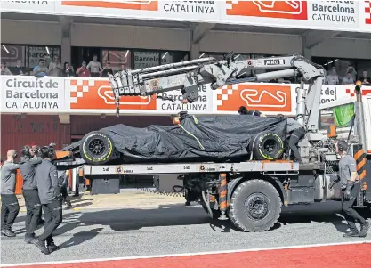  ??  ?? McLaren mechanics bring Fernando Alonso’s car back to the pit lane.