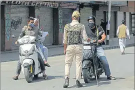  ?? WASEEM ANDRABI/HT ?? A cop stops commuters on a road in Srinagar on Friday.