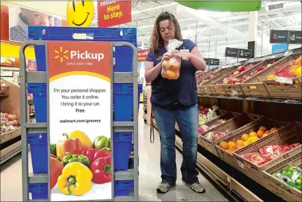  ?? SARAH HALZACK/THE WASHINGTON POST ?? April Styers, a personal shopper for the Wal-Mart pickup program, selects fresh produce for customers’ orders.