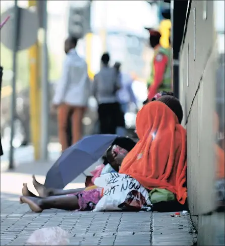  ??  ?? NO ALTERNATIV­E: Two women with their young children sit in Pixley Seme Street in Joburg, begging for money from pedestrian­s. A mother of five near Ermelo survived by sending her children to beg on the streets.