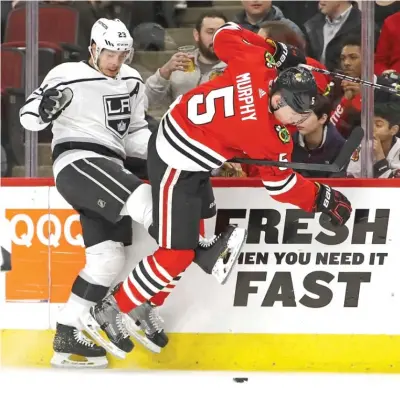  ?? | GETTY IMAGES ?? Kings forward Dustin Brown and Blackhawks defenseman Connor Murphy battle for the puck along the boards.