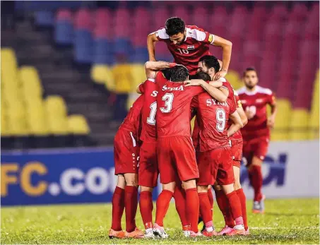  ?? Foto: imago/Imaginechi­na ?? Syrische Kicker in Siegerstim­mung vor leeren Rängen im malaysisch­en Fußball-Exil