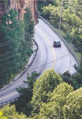  ?? STAFF PHOTO BY DOUG STRICKLAND ?? A lone car travels along a section of Signal Mountain Boulevard on Wednesday. Beginning today, the road will be reduced to one lane as crews from GeoStabili­zation Internatio­nal begin eight weeks of repairs to its upper section.