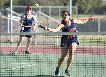  ?? RECORDER PHOTO BY CHIEKO HARA ?? Strathmore High School’s Lauren Leyva, right, volleys the ball as her teammate Elizabeth Fischer covers her back Thursday, during the No. 3 doubles match against Kern High School at Strathmore.