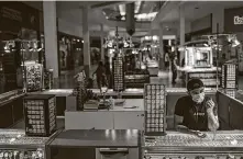  ?? Jon Shapley / Staff photograph­er ?? Mohammad Irfan waits for customers Friday at PlazAmeric­as mall, which is open at reduced capacity.