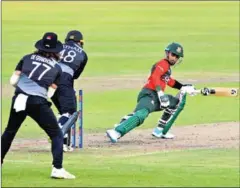  ?? AFP ?? New Zealand’s captain Tom Latham (centre) breaks the stumps to dismiss Bangladesh’s Liton Das (right) during the first Twenty20 internatio­nal cricket match on Wednesday.